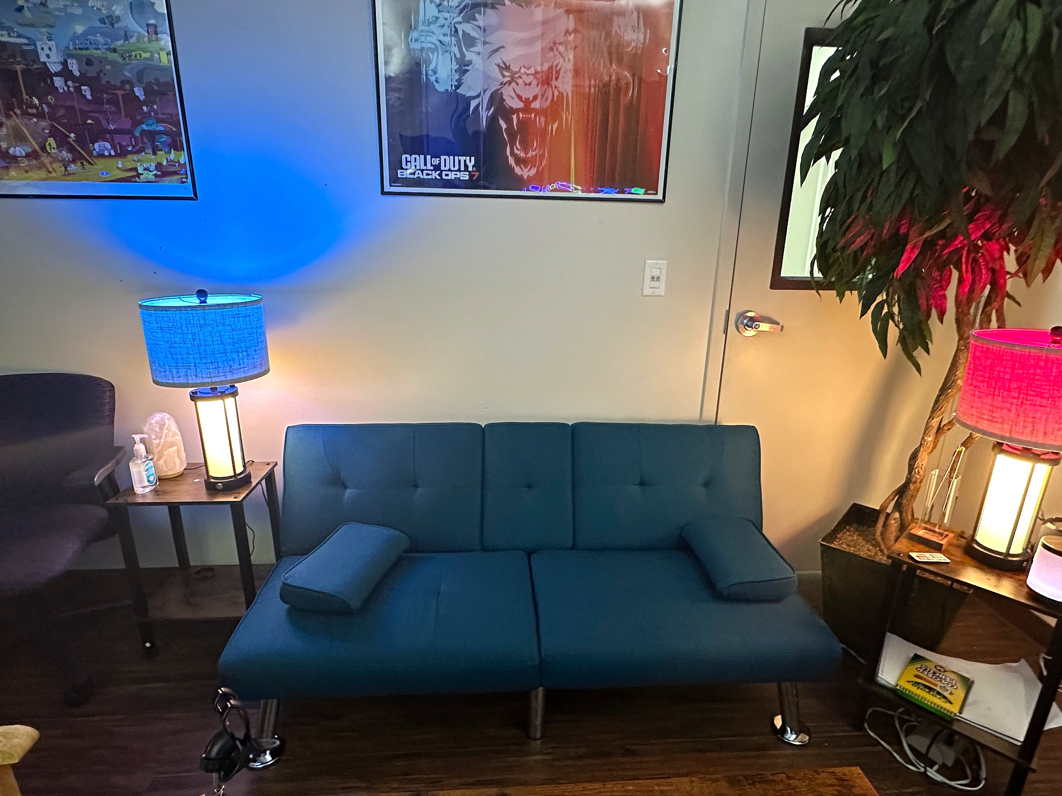 Gaming lounge with blue futon and gaming posters